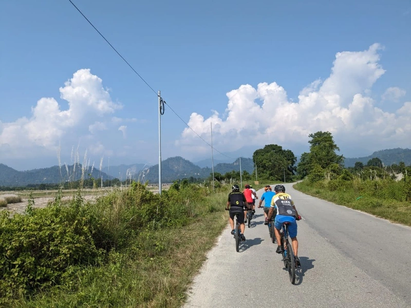 Cyclists riding through Assam on the Brahmaputra Explorer tour