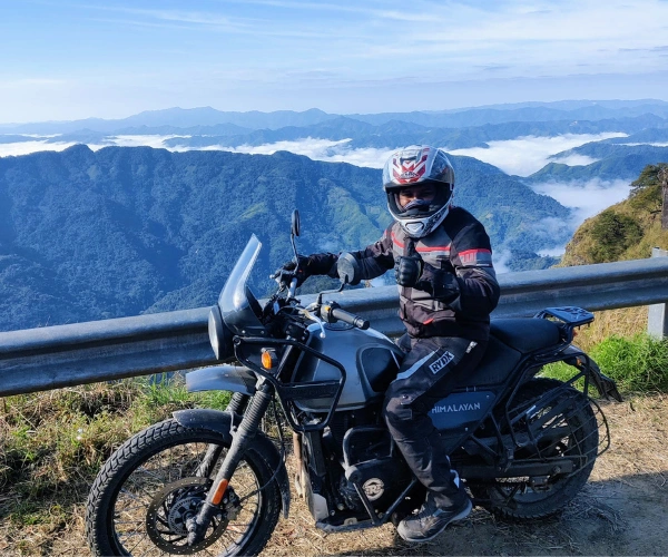 Rider above misty mountains on a Northeast India motorcycle tour