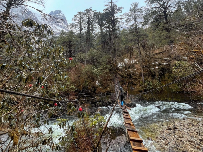 Walker crossing a bridge in Aeyo Valley