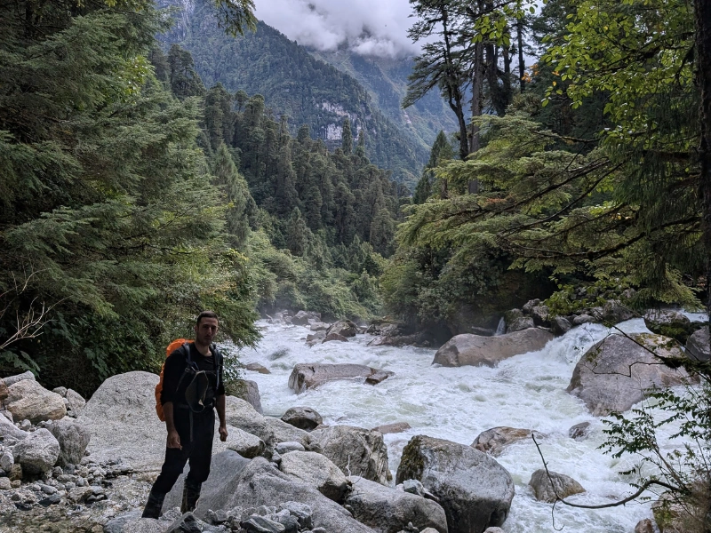 Trekker beside a fast river in the Aeyo Valley of Arunachal Pradesh