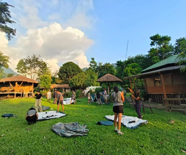 Youth expedition group preparing camp equipment in an Arunachal village