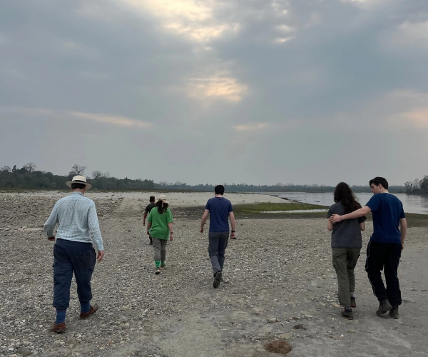 Family walk along a riverbank in Assam