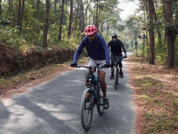 Cyclists riding through pine forest roads between Shillong and Kohima