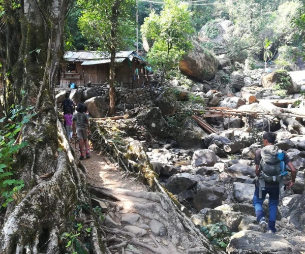 Youth expedition group walking through a forest village in Meghalaya