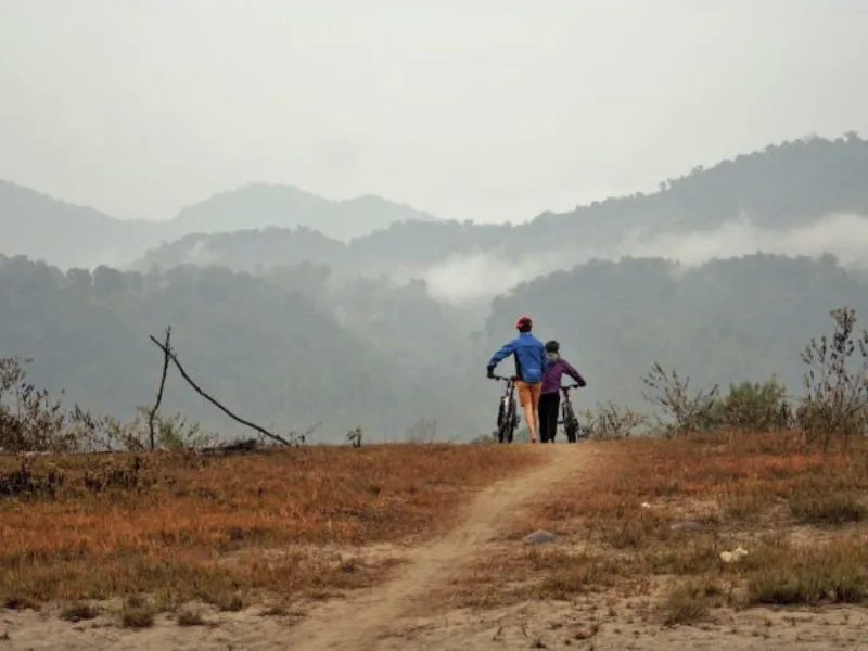 Cyclists looking across misty hills in Eastern Arunachal Pradesh