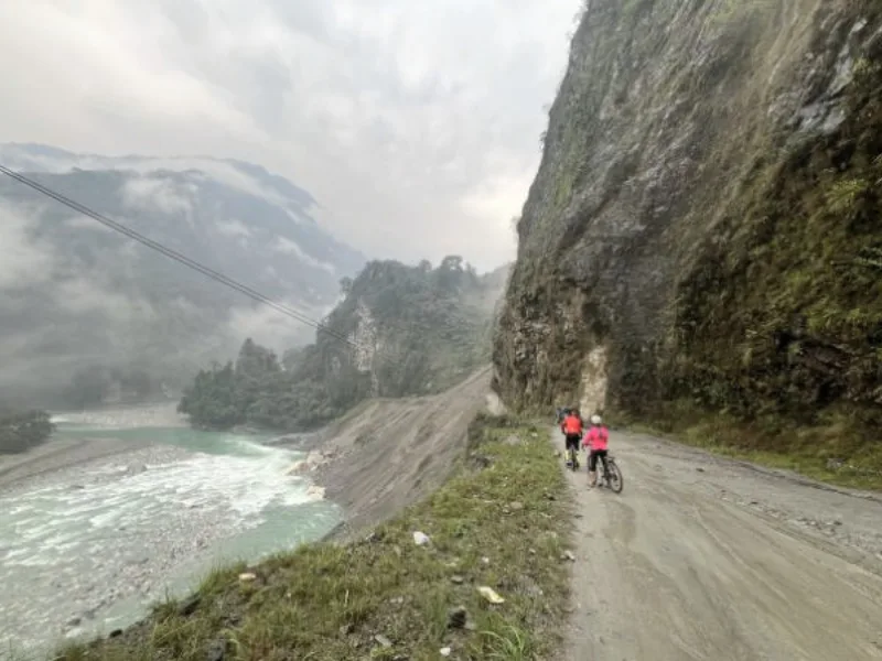 Cyclists on a cliffside road in the Mishmi Hills