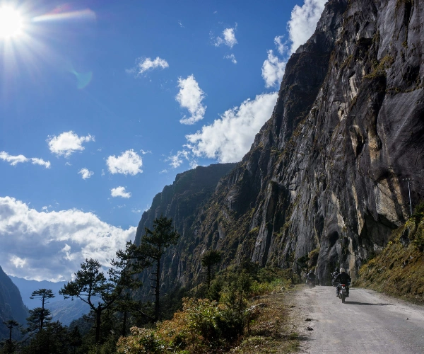 Motorcycle riding below cliffs in Western Arunachal Pradesh