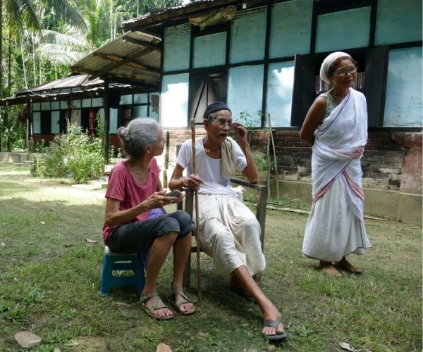 Village elders outside a traditional home in Assam