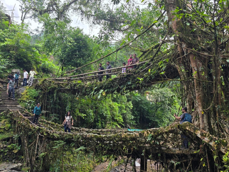 Walking group on a stone bridge in Meghalaya
