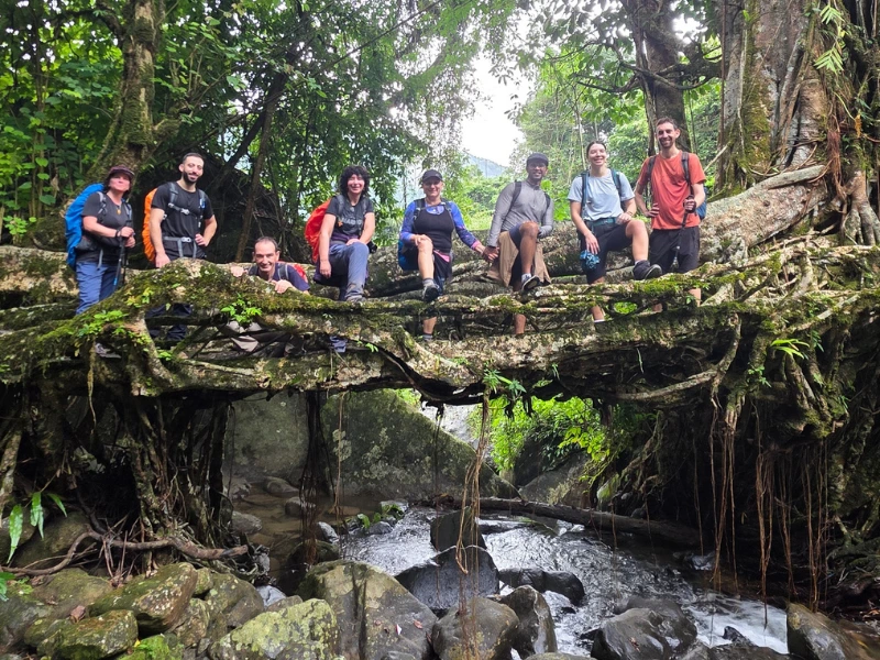 Walkers crossing living root bridges in Meghalaya