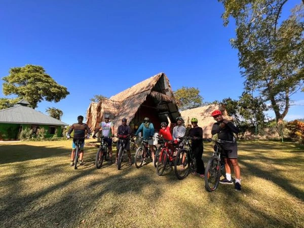 Cycling group beside a traditional house in Arunachal Pradesh