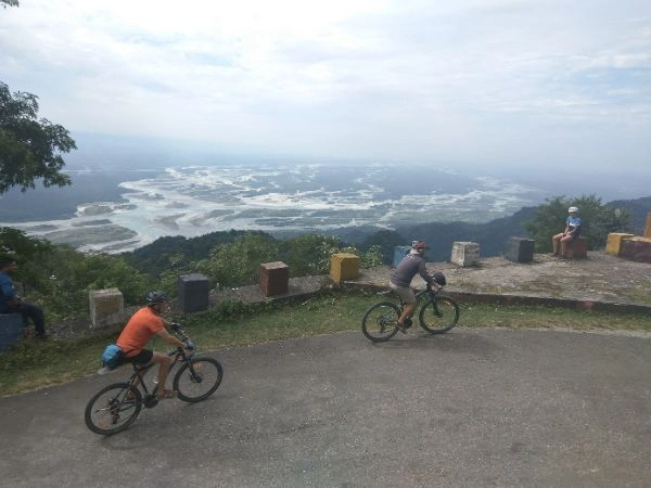Cyclists descending toward the eastern Brahmaputra valley