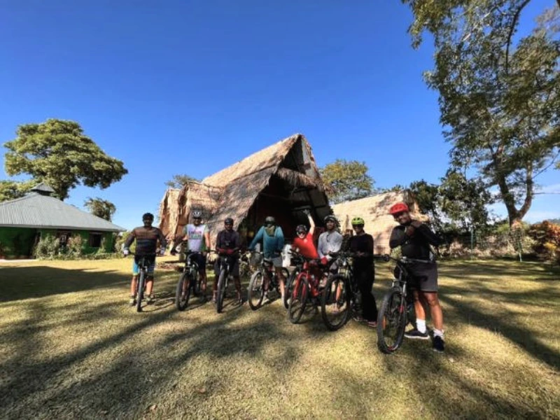 Cycling group with bicycles outside a traditional house in Eastern Arunachal Pradesh