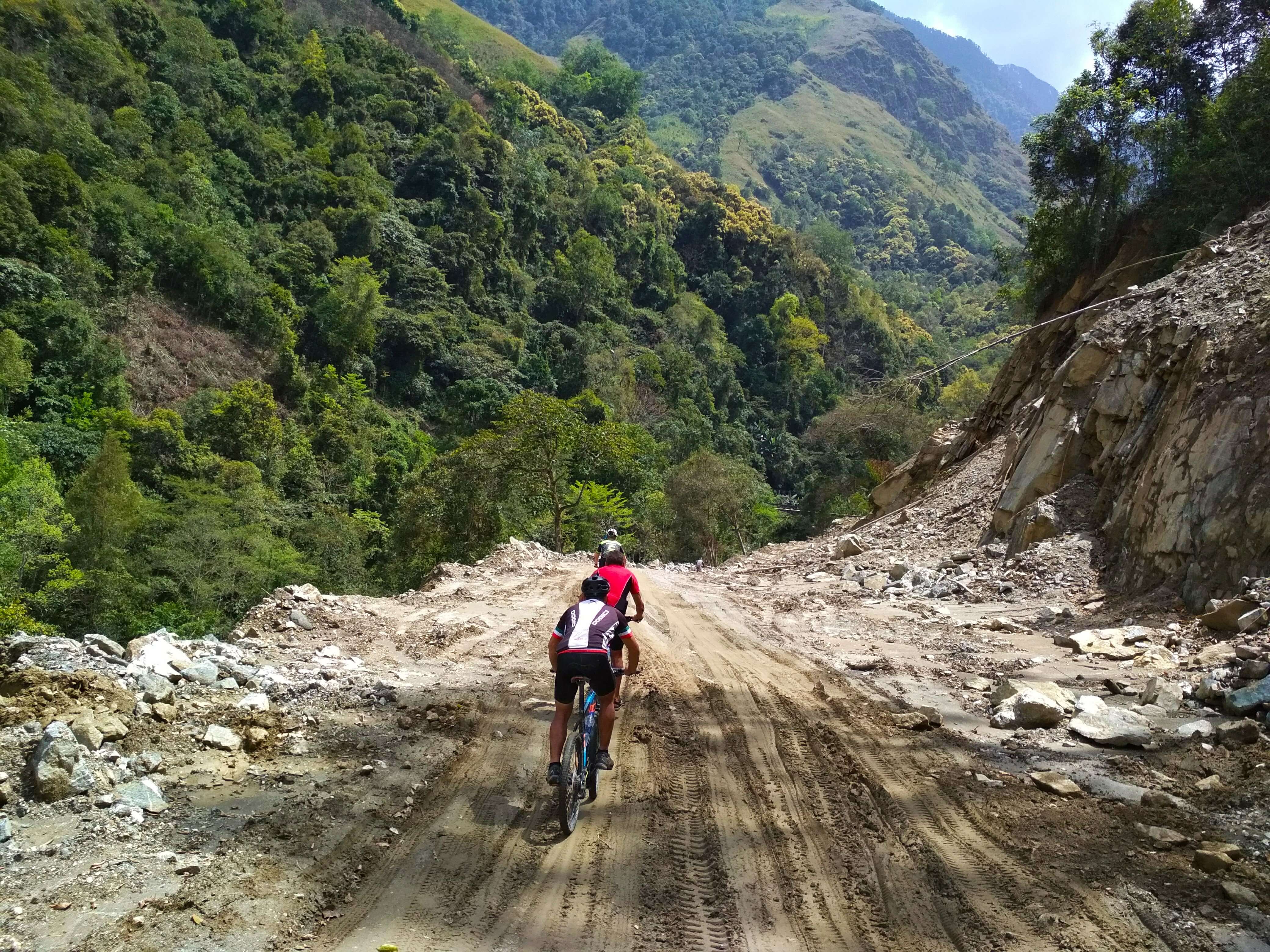 Three cyclists on a dirt road up the mountain